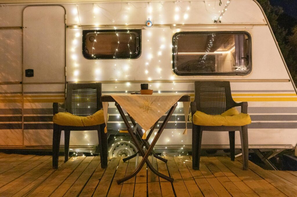 Mesa y sillas de camping junto a una caravana